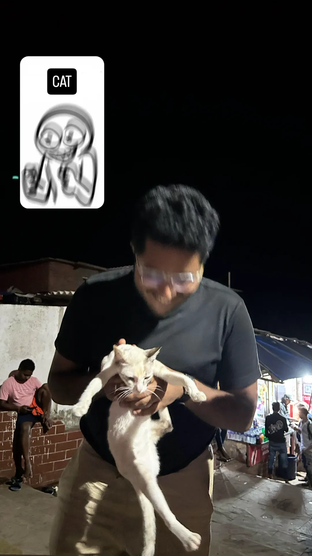 Sid laughing while holding a cat